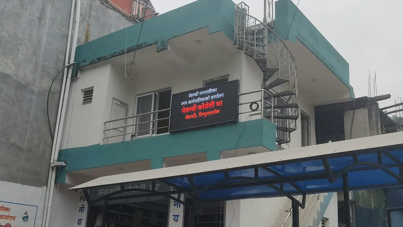 Outdoor LED display board mounted on the first-floor facade of the Melamchi Municipal Executive Office building in Sindhupalchok, Nepal.