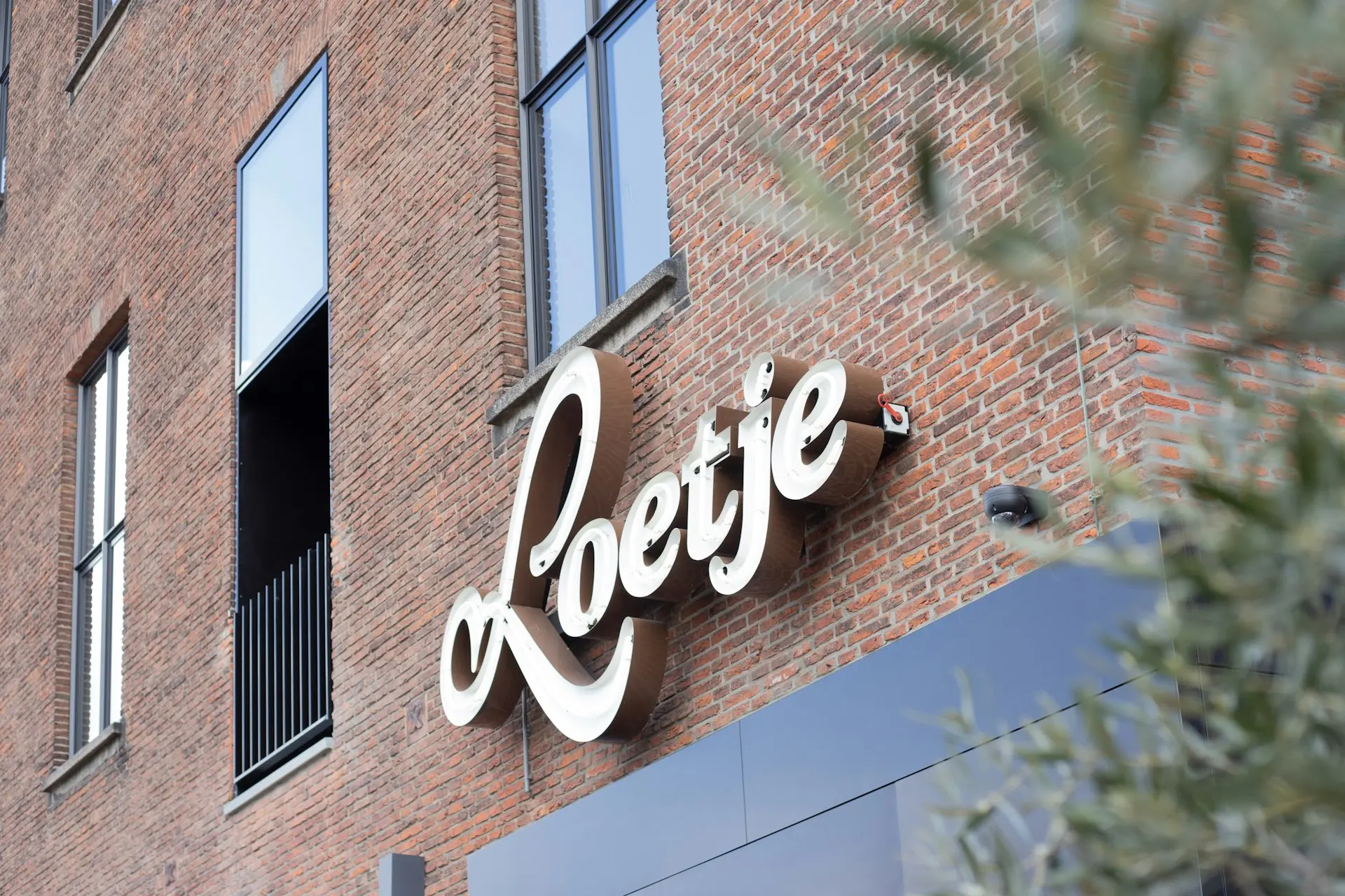 brown brick building with white love neon signage